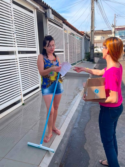 Profissional realizando distribuição de material em ação porta a porta