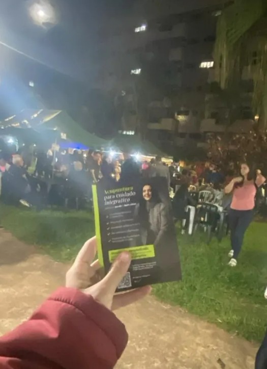 Equipe realizando distribuição de materiais em feira com circulação de pessoas